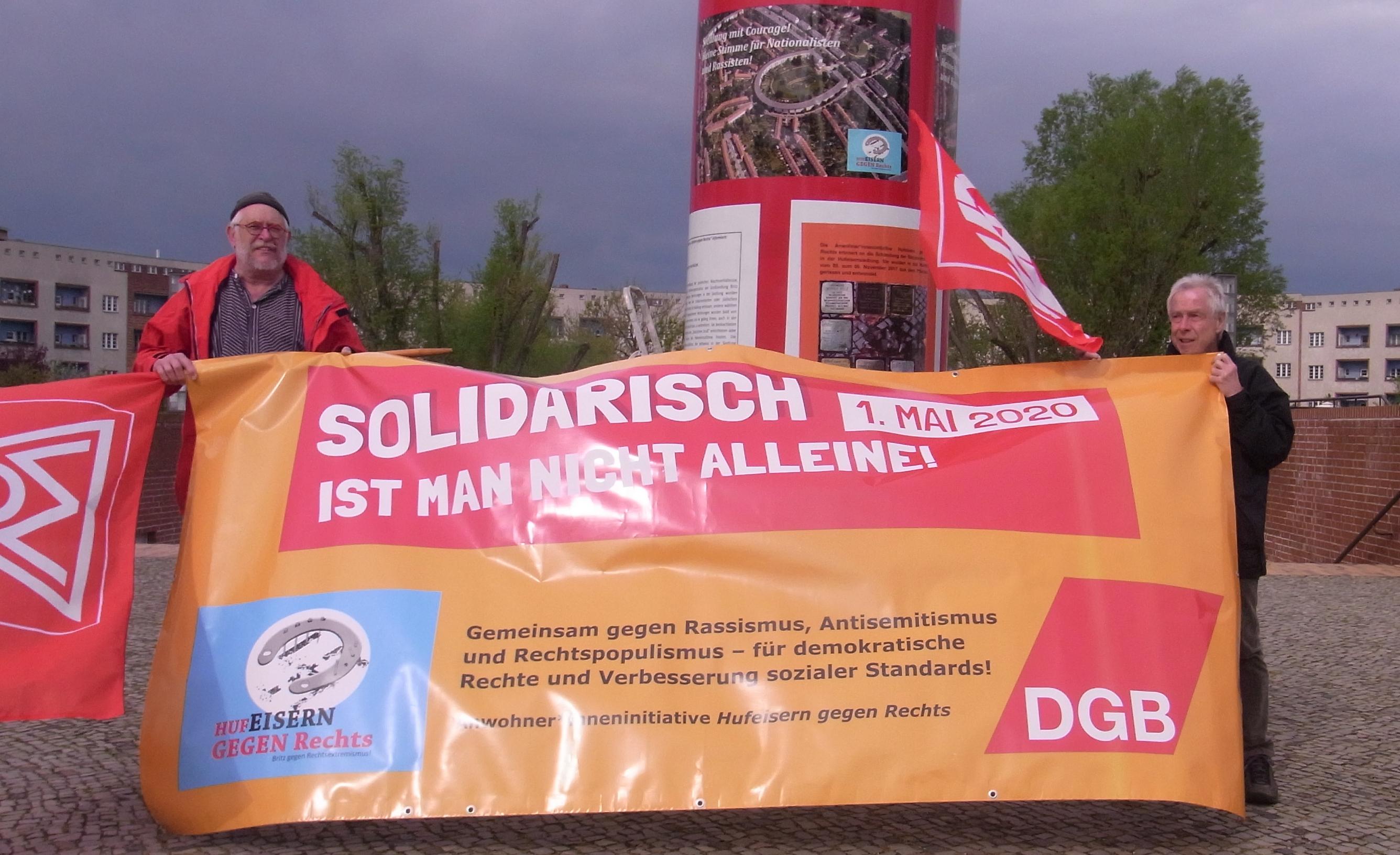 Das DGB Plakat wird von Aktivisten gezeigt